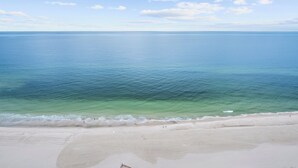 Una playa con aguas azules cristalinas y una orilla arenosa.