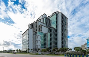 Um edifício moderno de vários andares com fachada de vidro, provavelmente um hotel ou complexo de escritórios.