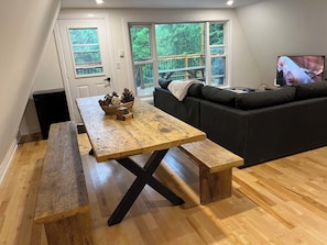 Relax in the living room with a dining table for meals and gatherings, a comfortable sofa, and a TV for entertainment.