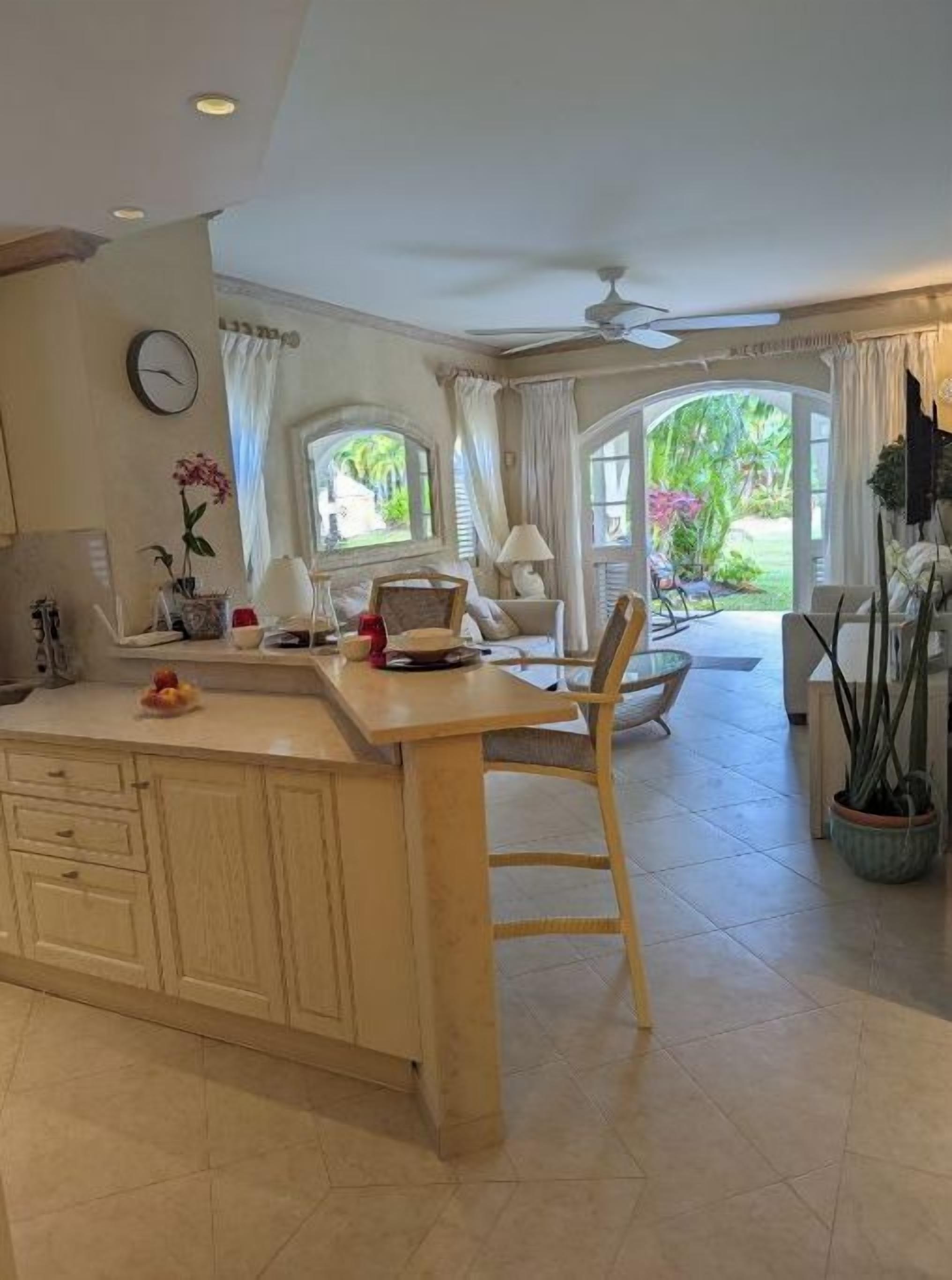 Una cocina amplia con una isla grande, armarios de madera y un comedor con una silla.