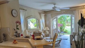 A spacious kitchen with a large island, wooden cabinets, and a dining area with a chair. - Sugar Hill Resort, St.James (Mount Standfast)