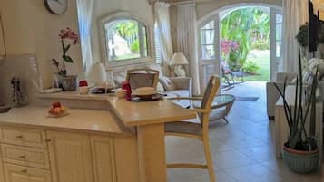 Una cocina amplia con una isla grande, armarios de madera y un comedor con una silla.