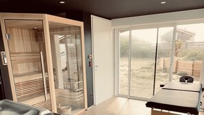 A spa area with a hot tub, wooden sauna, and a massage table. - "La Villa Tchanquée " Dominant view of the Ocean & Pines (Soorts-Hossegor)