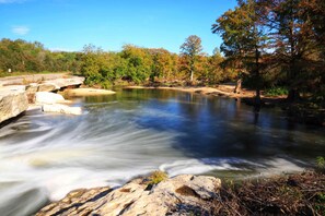 A river with smooth water flow, surrounded by rocks and trees.