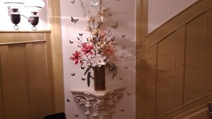 Eine Treppe mit einer Wandverkleidung, verziert mit einer Blumenkomposition und Schmetterlingsmotiven.