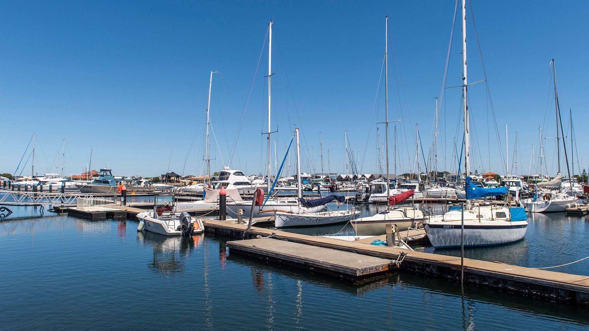 Un puerto deportivo con varias embarcaciones amarradas a muelles de madera.