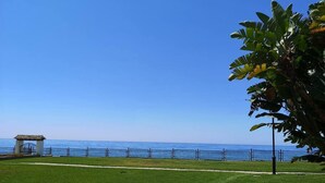 Un'area verdeggiante con un piccolo padiglione e una recinzione che si affaccia su un corso d'acqua.