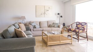 Un soggiorno con divano, poltrone, tavolino e una poltrona decorata.