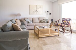 A living room with a sofa, armchairs, a coffee table, and a patterned chair.