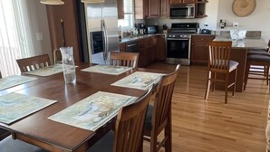 A spacious kitchen with wooden cabinets, stainless steel appliances, and a dining area with a large table and chairs. - 3-bd/3-bth, short walk to Salisbury beach and center - Winter Rentals Available (Salisbury)