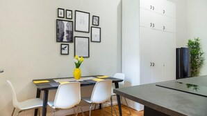 Un espace repas moderne avec une table, des chaises et des œuvres d’art encadrées accrochées au mur.