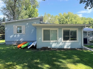 A small, single-story house with a front porch and two windows. - Waterfront Retreat | Millers Bay Canal Getaway (Milford)