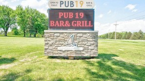 Señal digital para el Bar & Grill PUB19, indicando que está abierto al público.