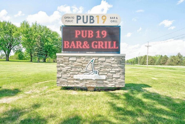 A digital sign for PUB19 Bar & Grill, indicating it is open to the public. - Waterfront Retreat | Millers Bay Canal Getaway (Milford)