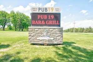 A digital sign for PUB19 Bar & Grill, indicating it is open to the public. - Boji Waterfront Retreat - Millers Bay Canals (Milford)
