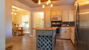 A kitchen with a central island, stainless steel appliances, and pendant lighting. - Family House (Omaha)