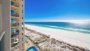 A beachfront hotel with multiple balconies, a pool, and a view of the ocean. - Exquisite 3 Bedroom Condo at Phoenix X 1006 (Orange Beach)