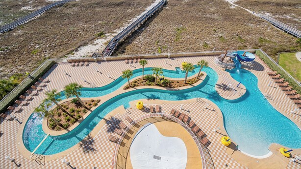 Un resort con un amplio área de piscina, un paseo marítimo y acceso a la playa.