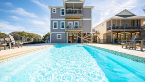 A large swimming pool with a multi-level building in the background. - Beach 45: Large, Modern Home Situated on the Davis Canal, Around 500 Feet to Bea (Oak Island)