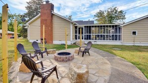 Un espace patio avec des sièges d’extérieur, un foyer et une cheminée en briques.