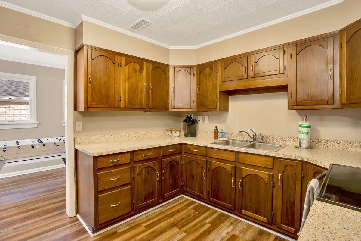 Una cocina con armarios de madera, encimera de granito y lavavajillas integrado.
