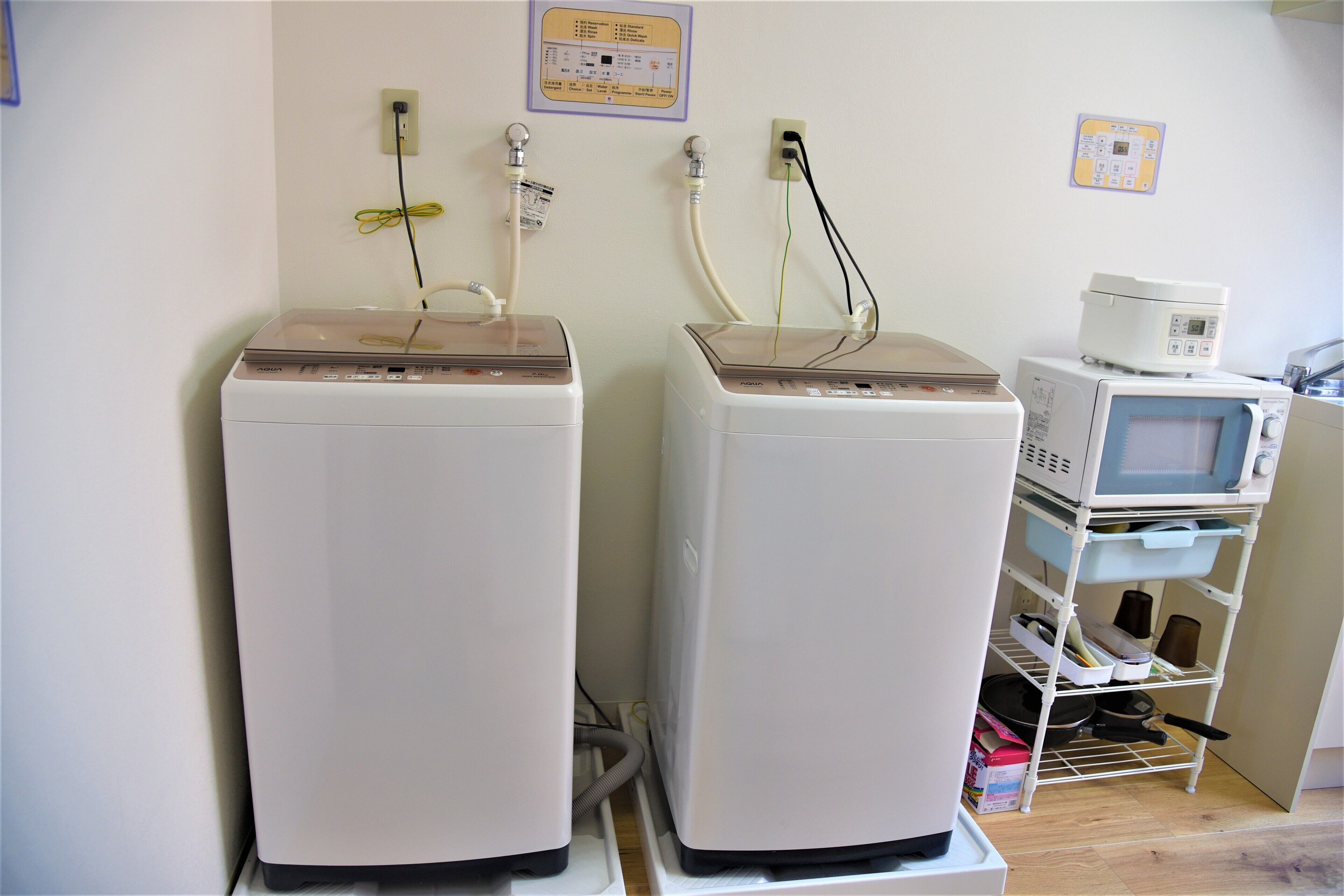 Two medical machines in a clinical setting, with a monitor and a shelf with various items.
