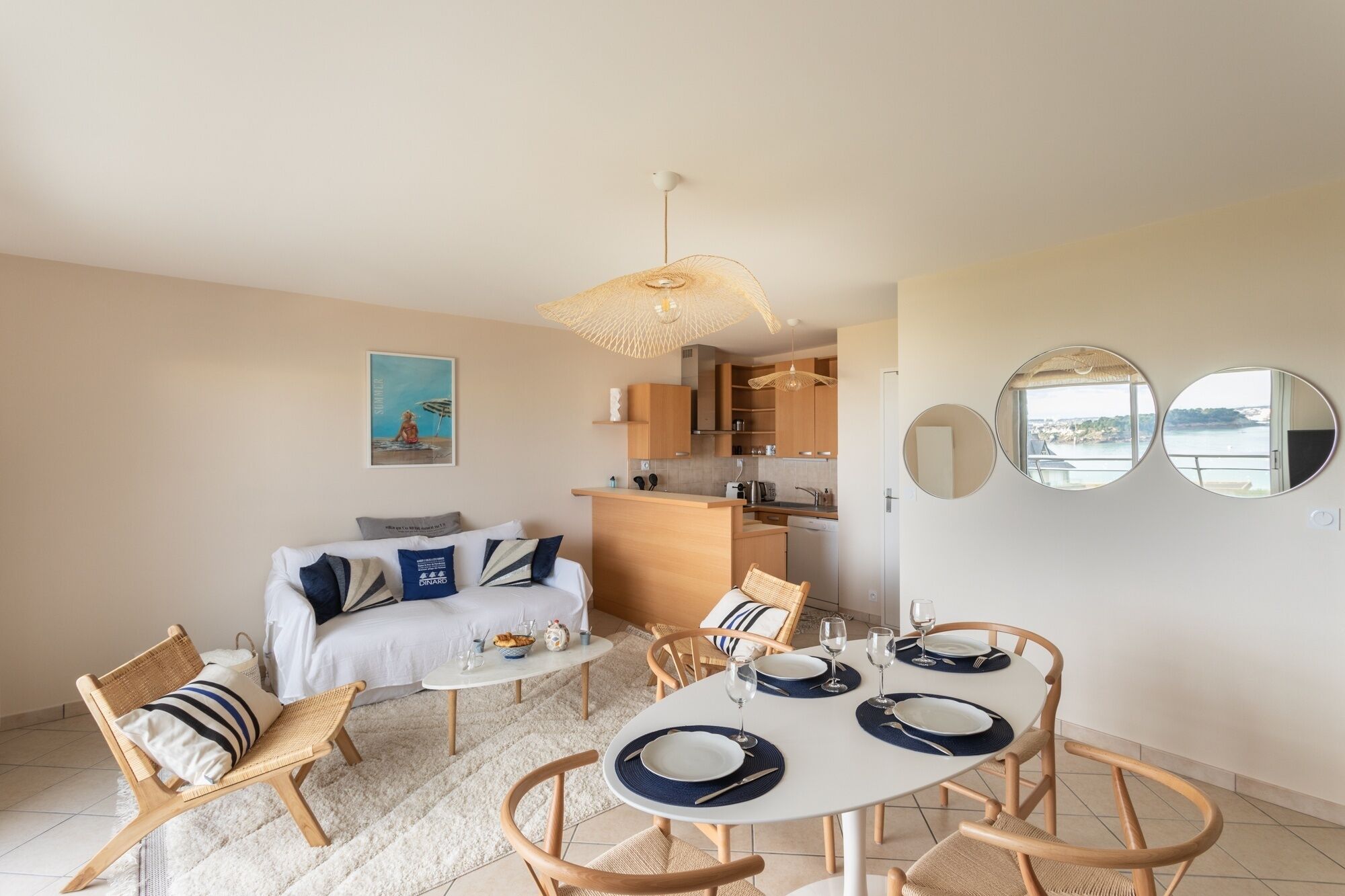 A compact living space with a dining area, kitchenette, and a sofa with cushions.