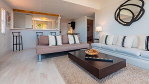 A modern living room with a sofa, a coffee table, and a kitchen area in the background. - Apartment near the center with wonderful views of Begur. (Begur)