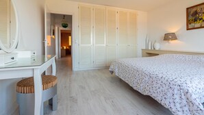 A bedroom with a bed, a desk, a mirror, and a wardrobe. - Apartment near the center with wonderful views of Begur. (Begur)