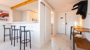 A modern kitchen with white cabinets, a wooden countertop, and three black bar stools. - Apartment near the center with wonderful views of Begur. (Begur)