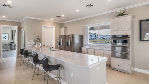 A modern kitchen with a large island, stainless steel appliances, and a view of the outdoors. - BEAUTIFUL 3BD 2.5BA TOWNHOME, POOL, GYM  by BHOF (Naples)