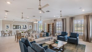 A spacious living room with a sofa, armchairs, a coffee table, and a dining area with chairs and a table. - BEAUTIFUL 3BD 2.5BA TOWNHOME, POOL, GYM  by BHOF (Naples)