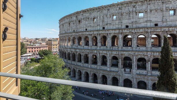 A historic coliseum with multiple arches and a crowd of people in the foreground. - Amazing 2-bedrooms apartment in front of the Colosseo  (Roma)