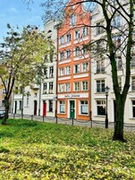 A multi-story building with a red facade and a sign that reads "Baltic Gdańsk."