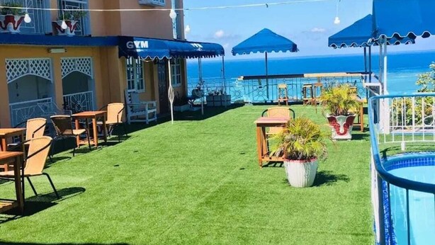 Un hotel con piscina, zona de estar al aire libre y vista al océano.