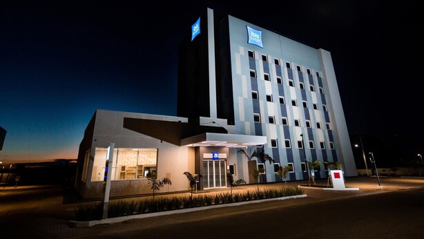 A modern hotel with a flat roof, a large entrance, and a sign indicating it is part of the ibis budget chain. - Ibis Budget Capao Bonito (Capao Bonito)