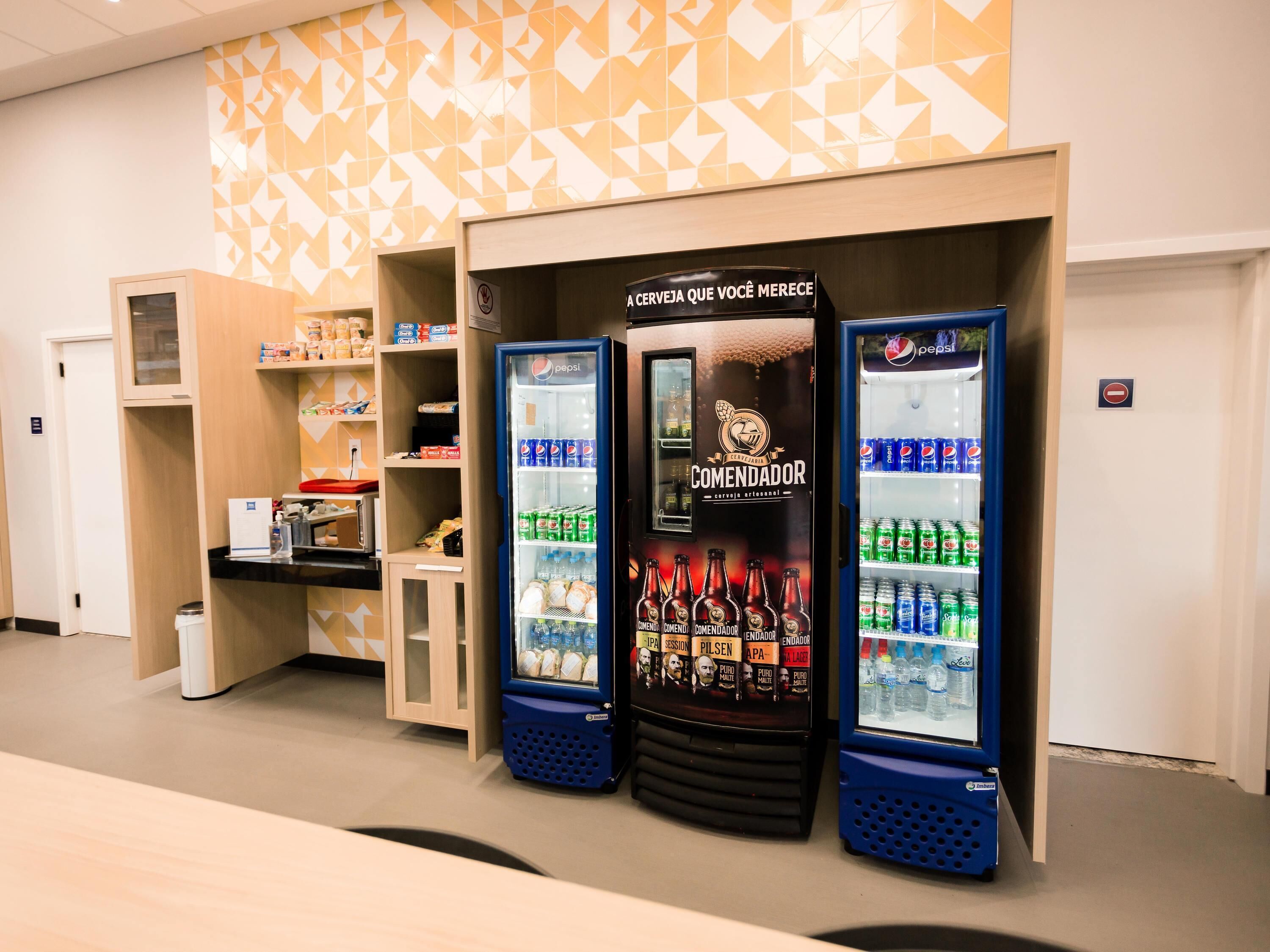 Vending machines with beverages and a wall with geometric patterns.