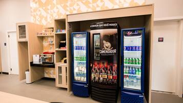 Vending machines with beverages and a wall with geometric patterns.
