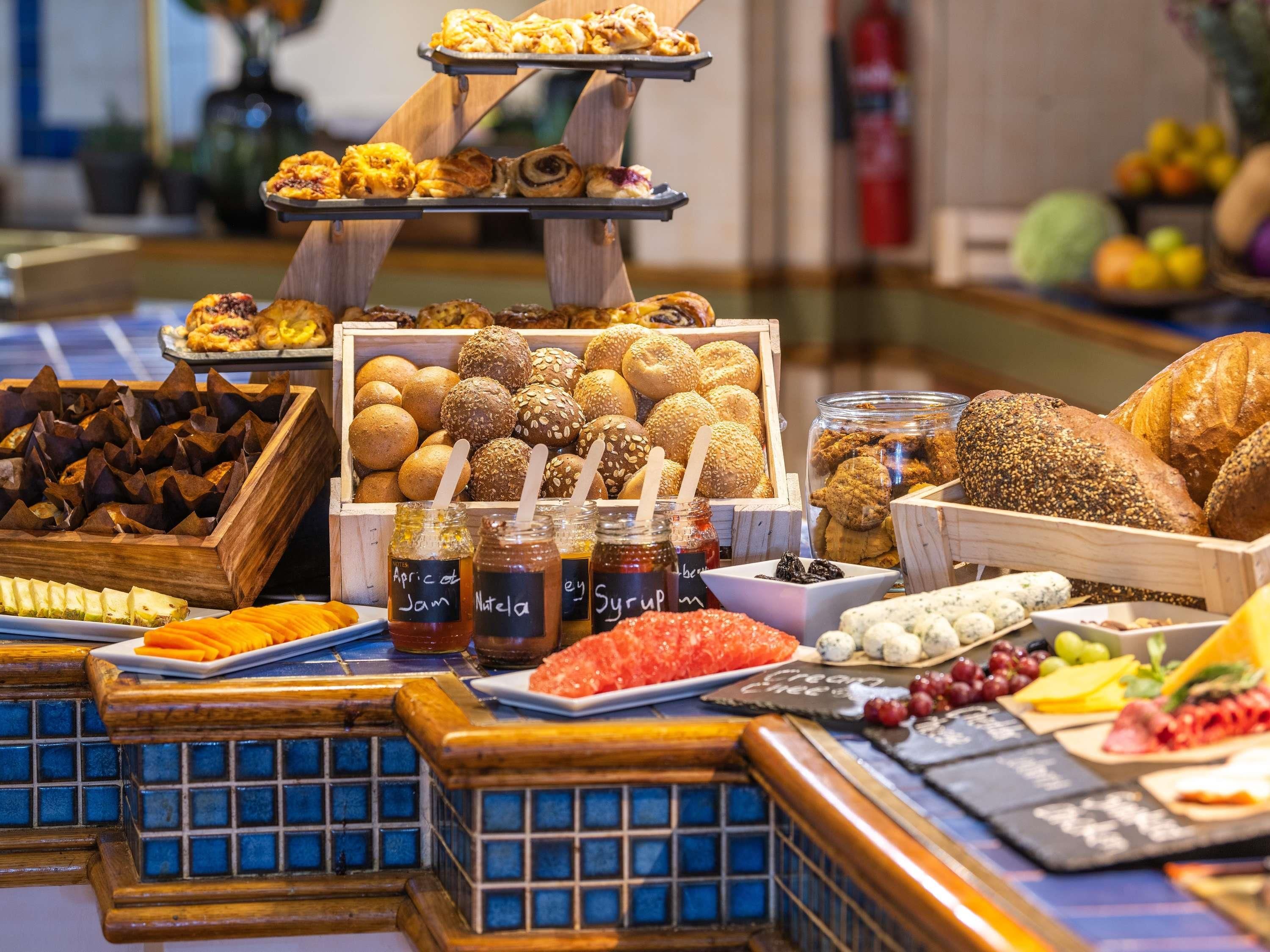 A buffet with various food items including bread, pastries, and condiments.