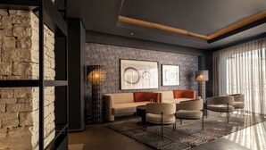 Una sala de estar moderna con una pared de piedra, un sofá, sillones y un tapete estampado.