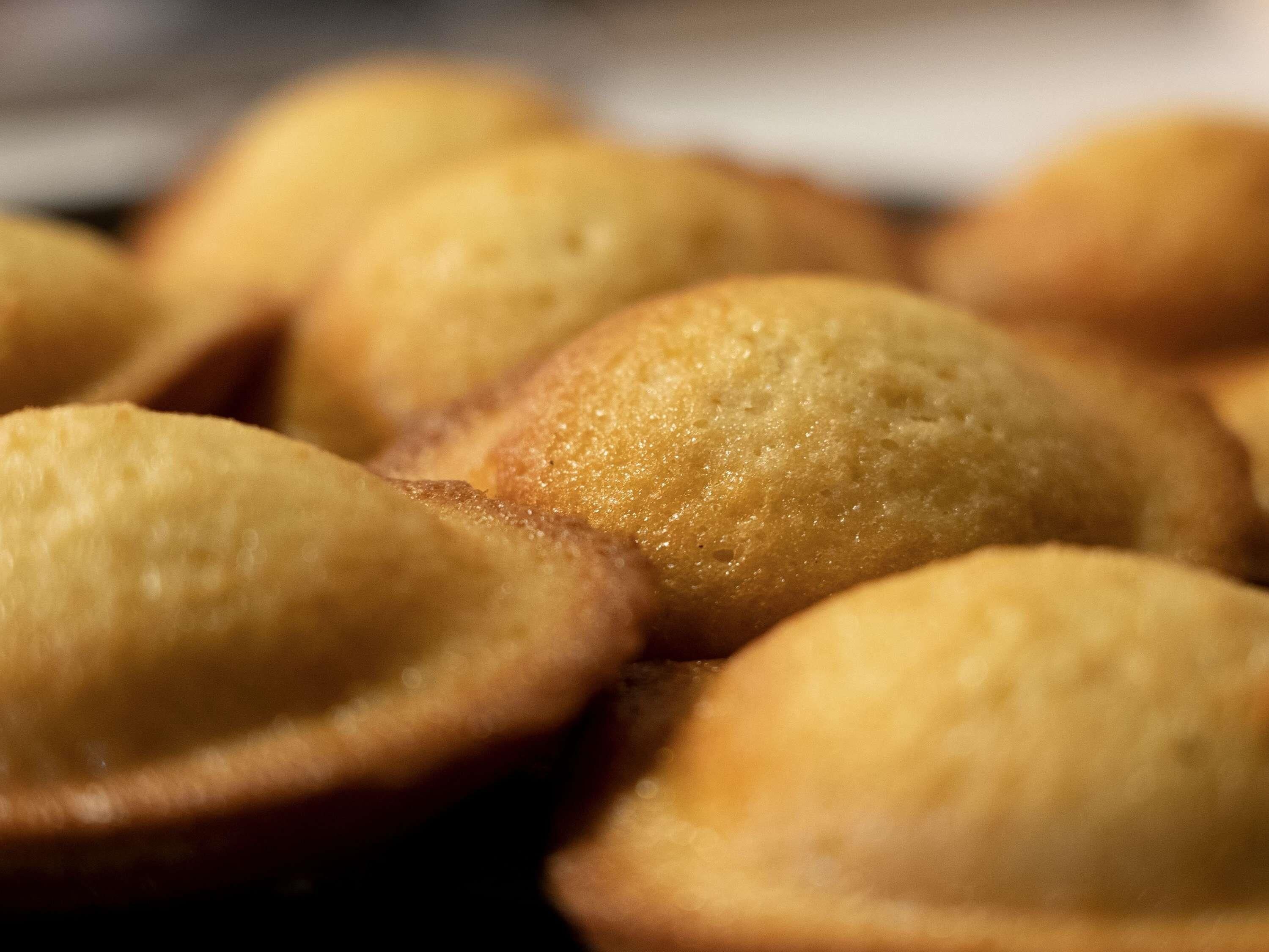En närbild på gyllenbruna bakverk, troligen muffins eller småkakor, med en mjuk och ojämn yta.