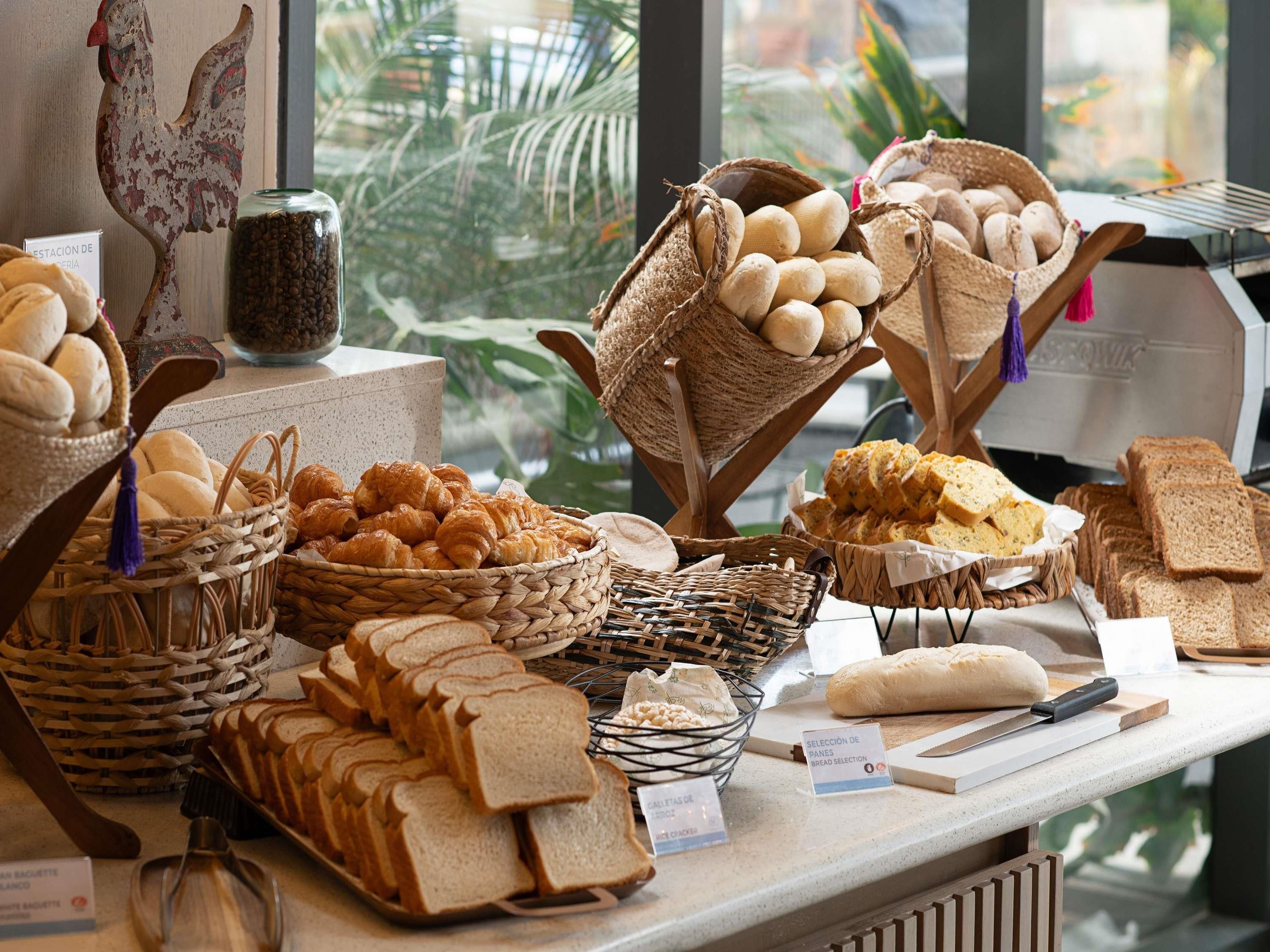 Mostrador de panadería con panes, pasteles y una decoración de gallo.