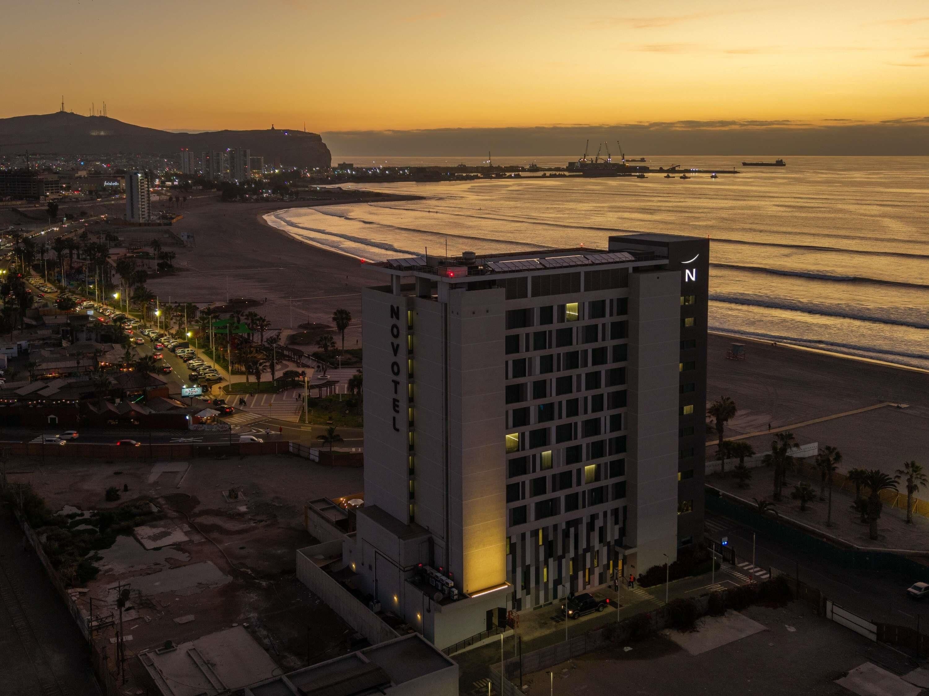 A hotel with a modern design, located near a beach with a view of the ocean.