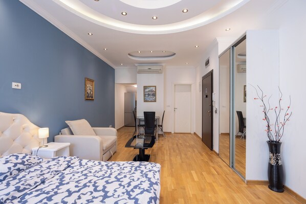 Une chambre d’hôtel moderne équipée d’un grand lit, d’un bureau, d’une chaise et d’un coin repas.