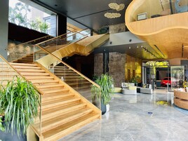 Un interior moderno con una escalera de madera, zonas de estar y una sala de exposición de Porsche.
