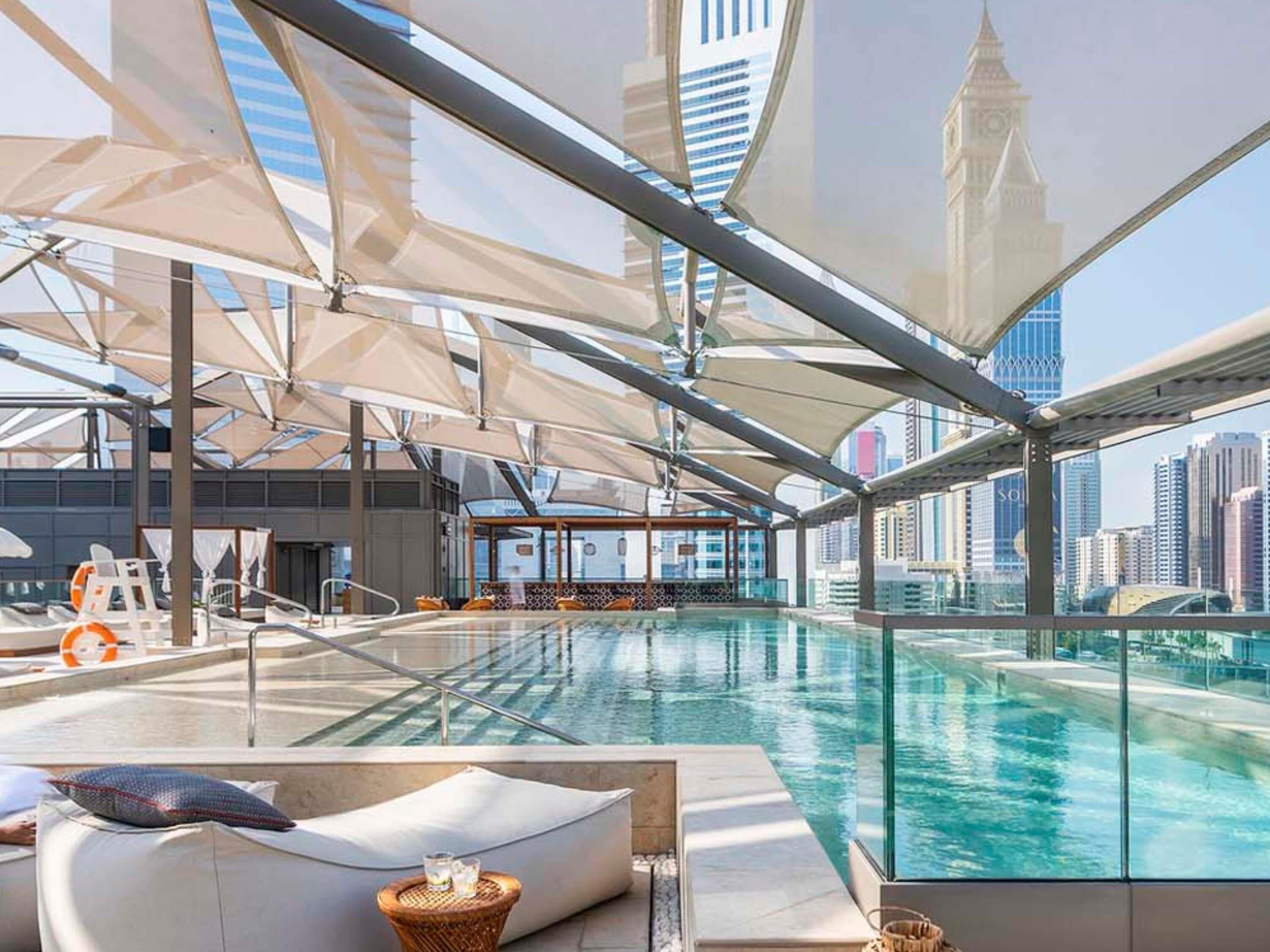 حمّام سباحة خارجي، مظلات على حمّام السباحة، مقاعد للتشمس