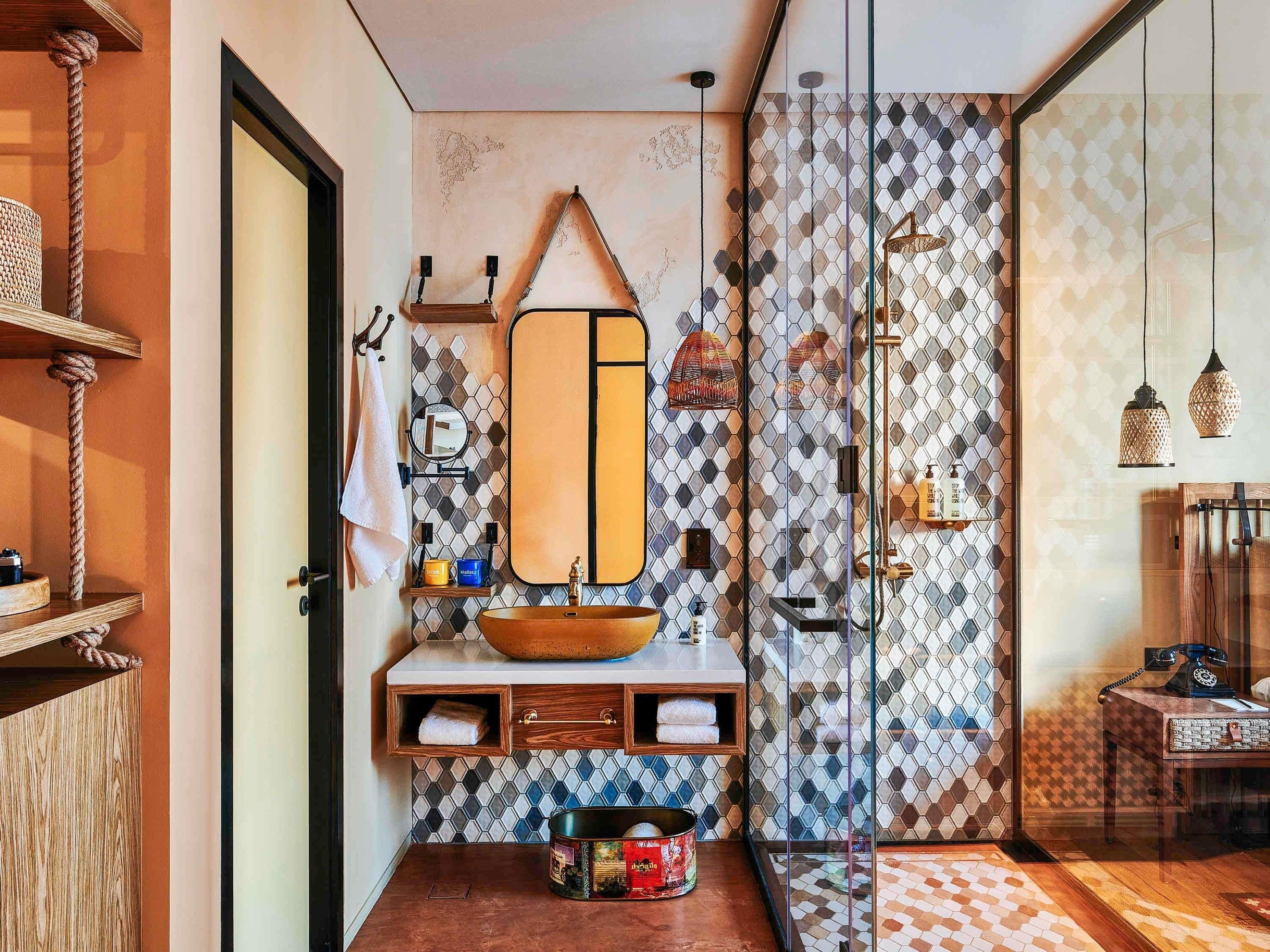 Un baño con un espejo grande, tocador de madera y cabina de ducha de vidrio.