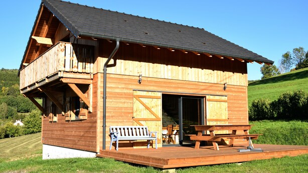 A wooden cabin with a balcony, a sliding door, and a picnic table. - Vosges mountain chalet (Ban-sur-Meurthe-Clefcy)
