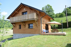 A wooden chalet with a balcony, a picnic table, and a covered outdoor seating area. - Vosges mountain chalet (Ban-sur-Meurthe-Clefcy)
