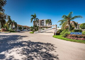 A multi-story hotel with a parking area and a clear sky.